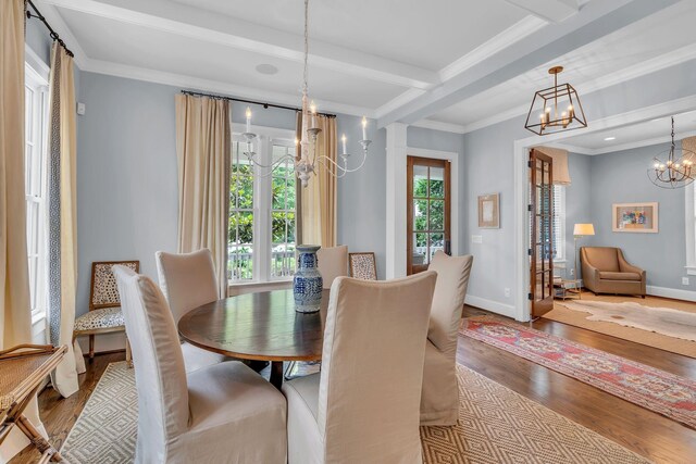 dining room featuring a chandelier, beamed ceiling, wood finished floors, and crown molding