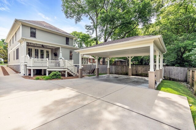 view of front facade with driveway, ceiling fan, stairs, fence, and a detached carport