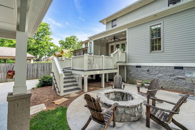 view of patio / terrace with a fire pit, a ceiling fan, stairs, fence, and a wooden deck