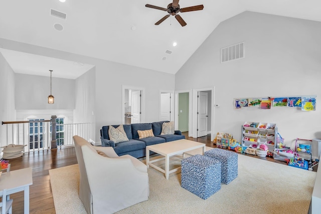 living room featuring high vaulted ceiling, visible vents, and wood finished floors