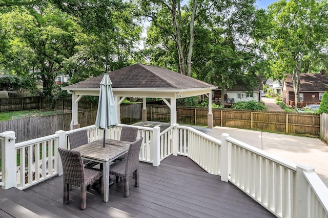 wooden deck with a gazebo, outdoor dining space, and a fenced backyard