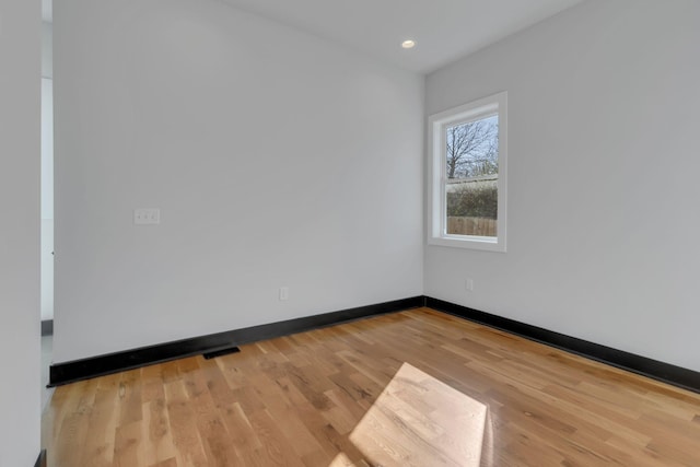 unfurnished room with visible vents, baseboards, wood finished floors, and recessed lighting