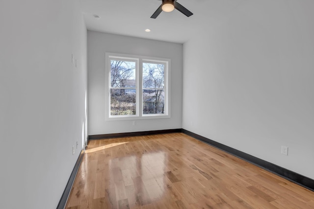 unfurnished room featuring a ceiling fan, light wood-type flooring, and baseboards