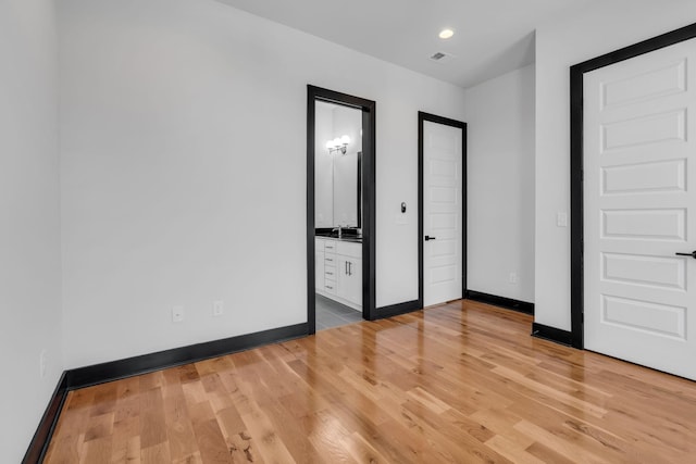 unfurnished bedroom featuring visible vents, baseboards, connected bathroom, light wood-style floors, and recessed lighting