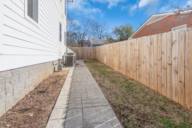 view of yard featuring a fenced backyard and central AC