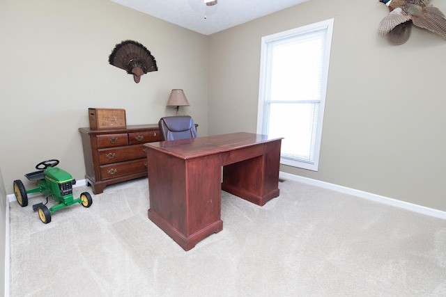 home office with light carpet, baseboards, and a ceiling fan