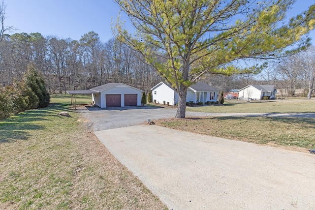 view of front facade featuring a garage, a front lawn, and an outbuilding