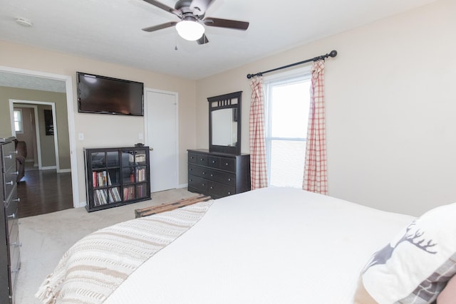 carpeted bedroom with ceiling fan and baseboards