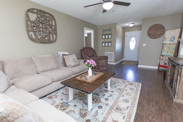 living room featuring baseboards, visible vents, a ceiling fan, wood finished floors, and a textured ceiling