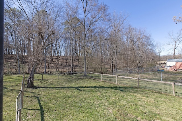 view of yard with fence and a rural view