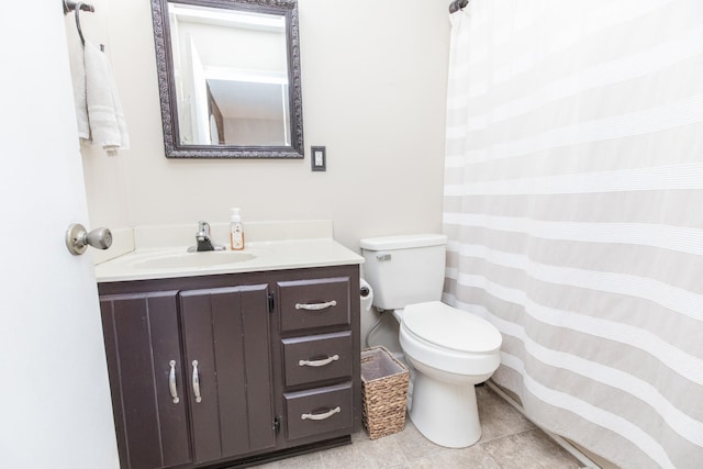 bathroom with a shower with curtain, vanity, toilet, and tile patterned floors