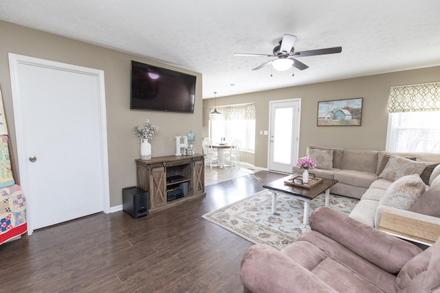 living area with a ceiling fan, a textured ceiling, baseboards, and wood finished floors