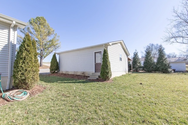 view of side of property featuring entry steps and a yard