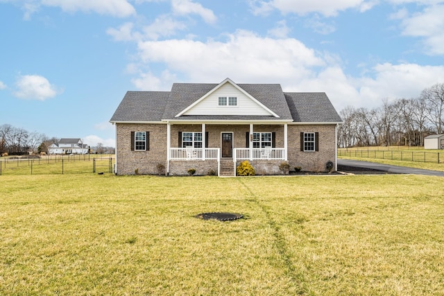 view of front of home featuring a porch, a shingled roof, brick siding, fence, and a front lawn