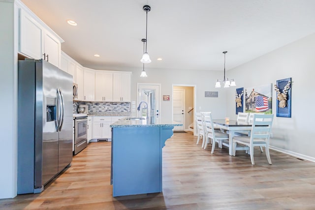 kitchen featuring a sink, white cabinetry, appliances with stainless steel finishes, light wood-type flooring, and tasteful backsplash