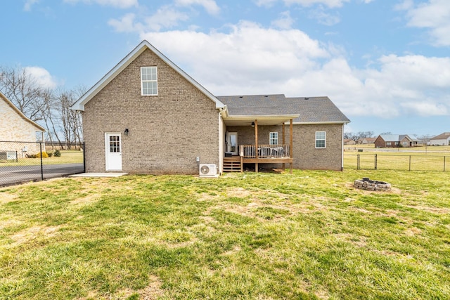 back of house featuring a deck, a yard, brick siding, and a fenced backyard