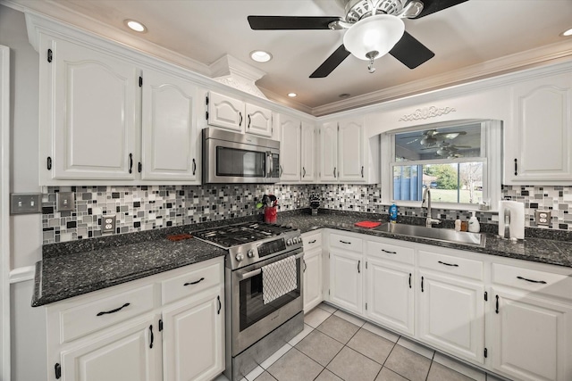 kitchen with appliances with stainless steel finishes, white cabinetry, a sink, and a ceiling fan