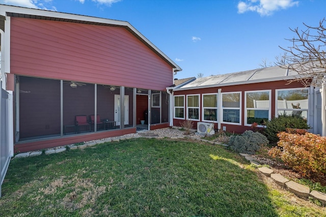 back of house with ac unit, a lawn, and a sunroom