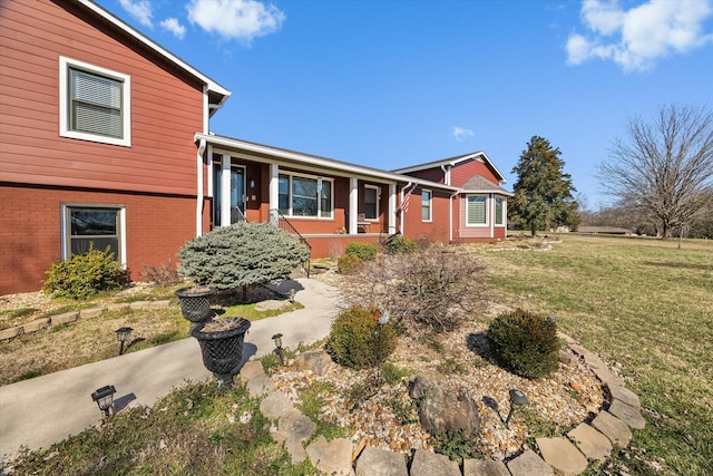 tri-level home with brick siding and a front lawn