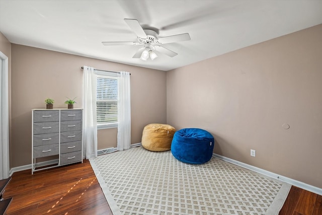 workout room with ceiling fan, wood finished floors, and baseboards