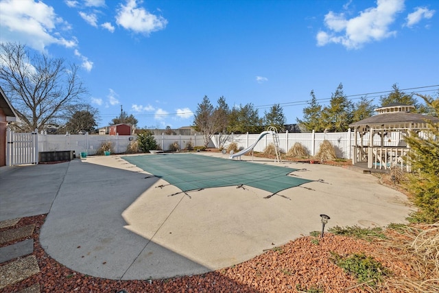 view of swimming pool featuring a patio, a water slide, a fenced backyard, a gazebo, and a fenced in pool