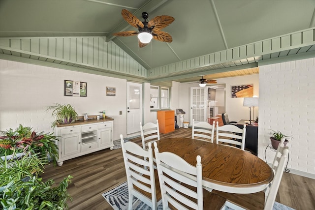 dining room with vaulted ceiling with beams, ceiling fan, brick wall, and dark wood finished floors