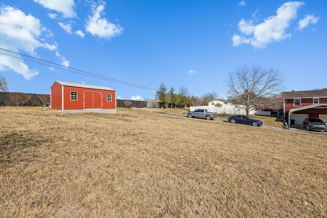 view of yard with a shed, fence, and an outdoor structure