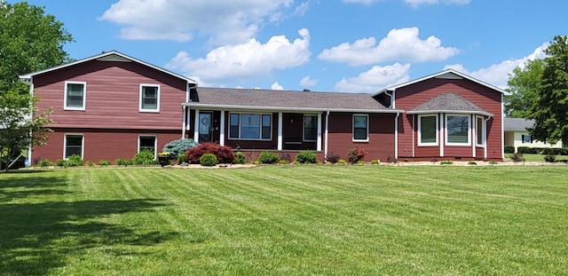 tri-level home with brick siding and a front yard