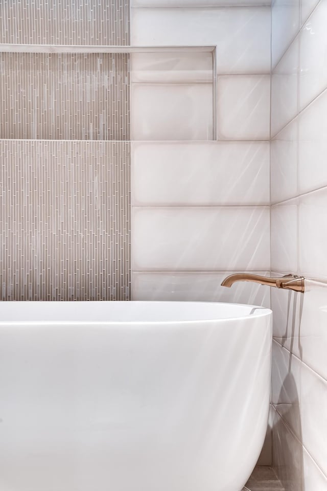 full bathroom featuring a soaking tub and tile walls