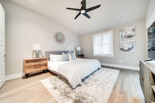 bedroom featuring vaulted ceiling, light wood-style flooring, and baseboards