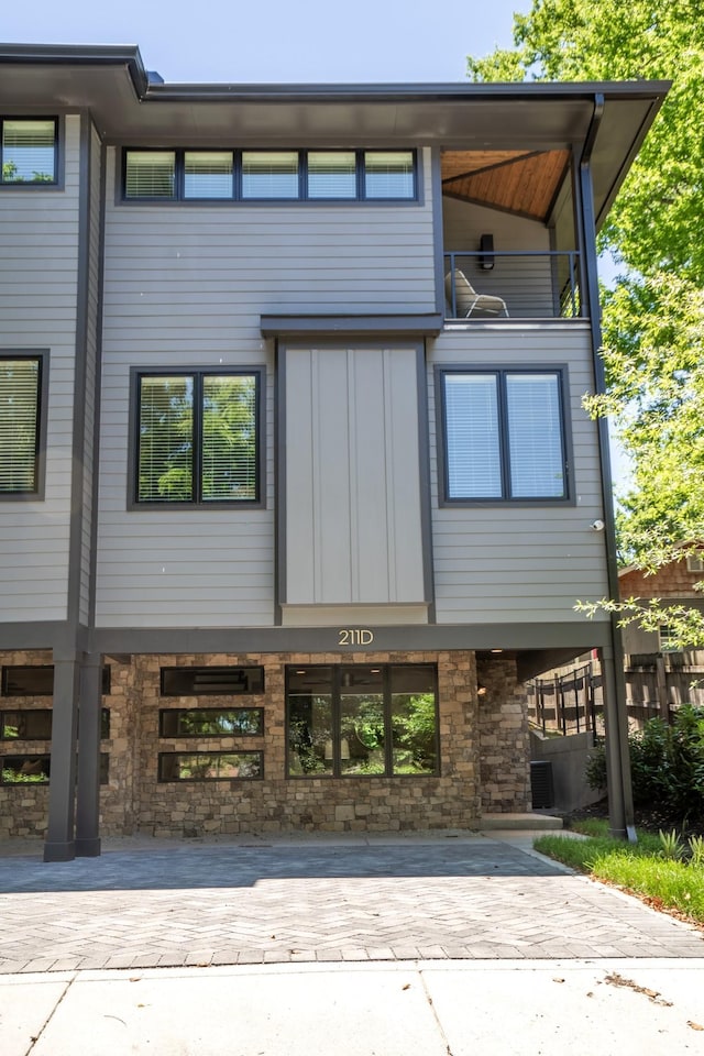 exterior space with a balcony and stone siding