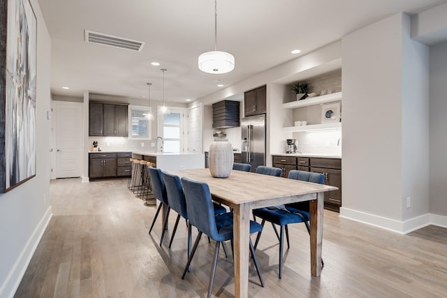 dining space featuring light wood finished floors, recessed lighting, visible vents, and baseboards