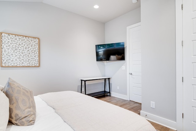 bedroom featuring vaulted ceiling, recessed lighting, wood finished floors, and baseboards