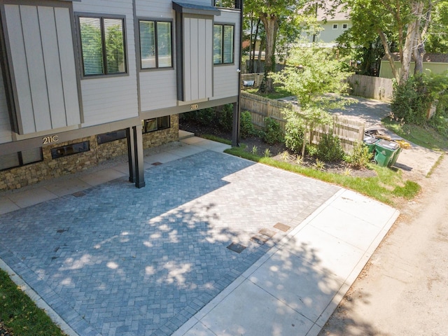 exterior space featuring stone siding, fence, and board and batten siding