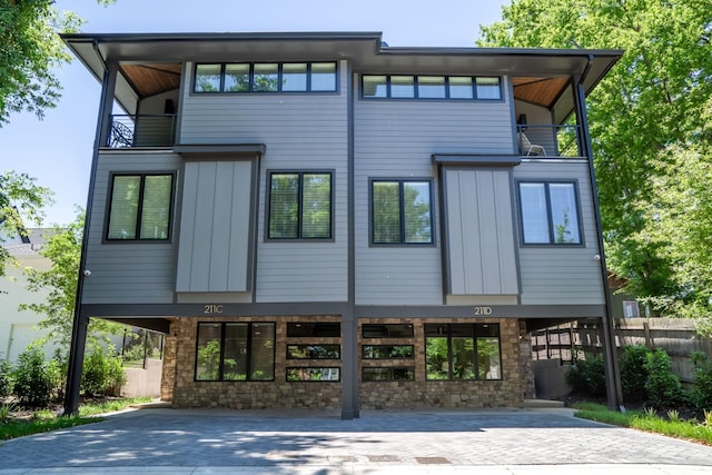 exterior space featuring decorative driveway, fence, and a balcony