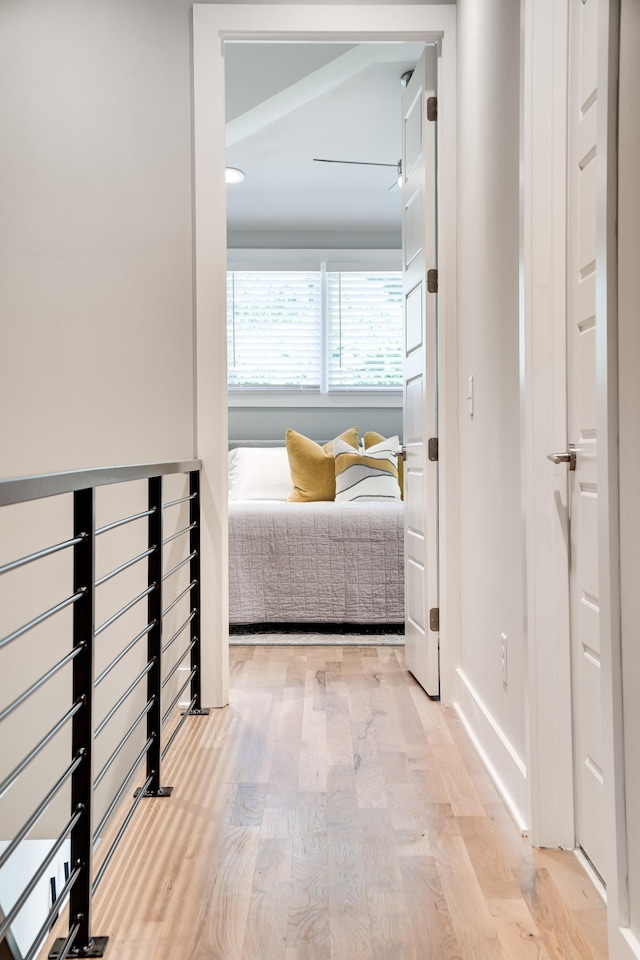 hall with baseboards and wood finished floors