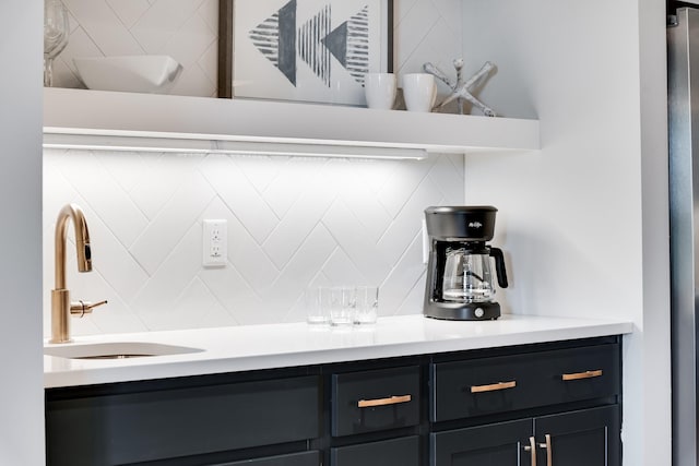 interior space with light countertops, a sink, and backsplash