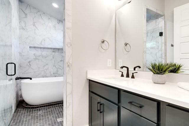 full bath featuring a freestanding tub, a marble finish shower, and vanity