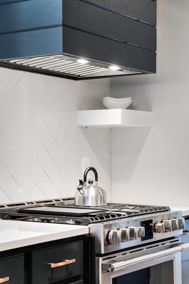 kitchen featuring stainless steel range with gas cooktop, light countertops, and backsplash