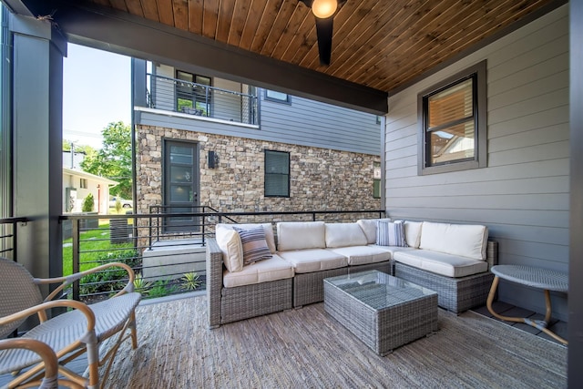 wooden terrace featuring outdoor lounge area and a ceiling fan