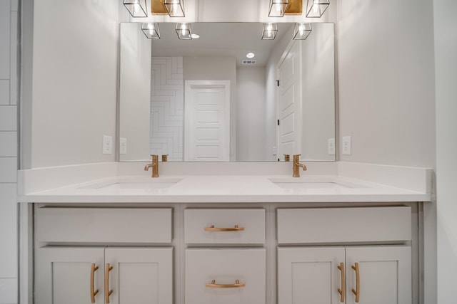 full bath with double vanity, visible vents, and a sink