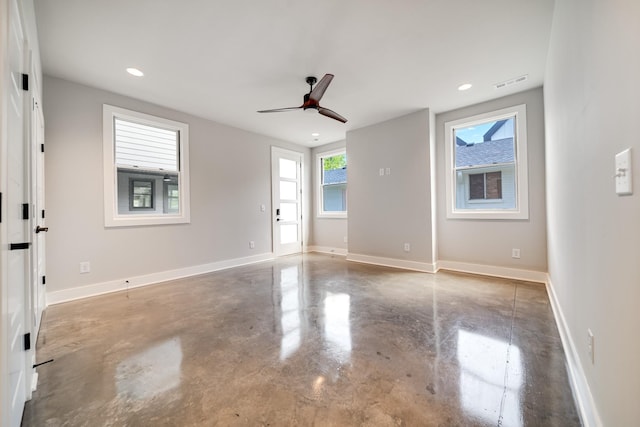 spare room featuring visible vents, finished concrete flooring, and baseboards