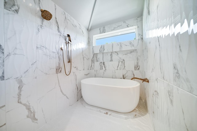 bathroom with a freestanding tub and a marble finish shower