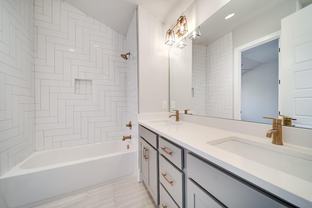 bathroom with double vanity, washtub / shower combination, and a sink