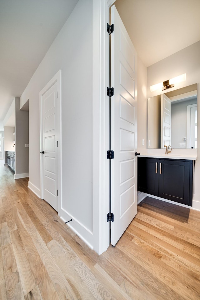 bathroom featuring vanity, baseboards, and wood finished floors