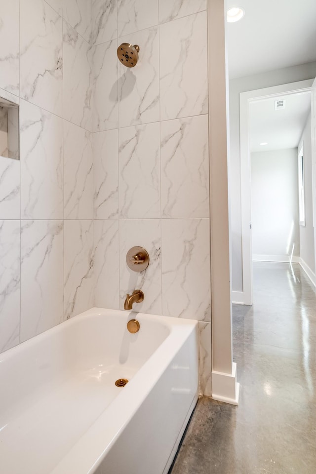 full bath with baseboards, concrete floors, visible vents, and tub / shower combination