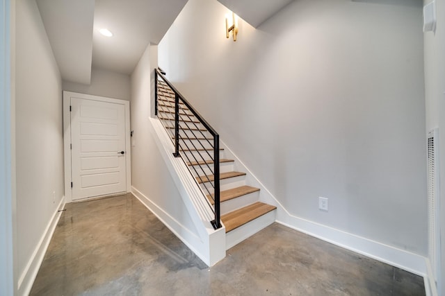 stairway with concrete flooring, recessed lighting, and baseboards