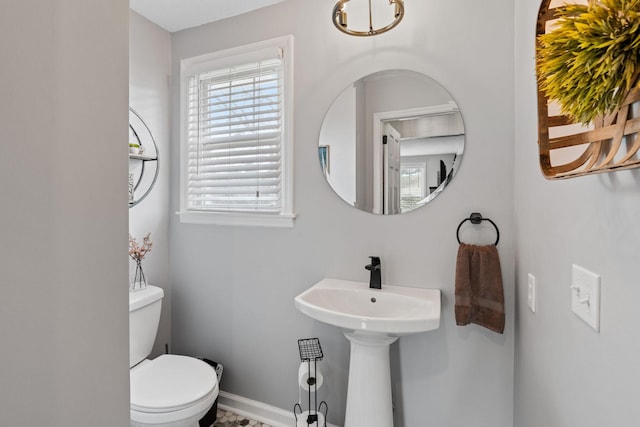 half bath with toilet and baseboards
