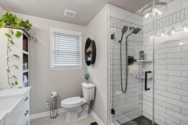 full bath featuring toilet, visible vents, baseboards, a shower stall, and tile patterned floors