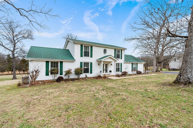 view of front of house featuring metal roof and a front lawn